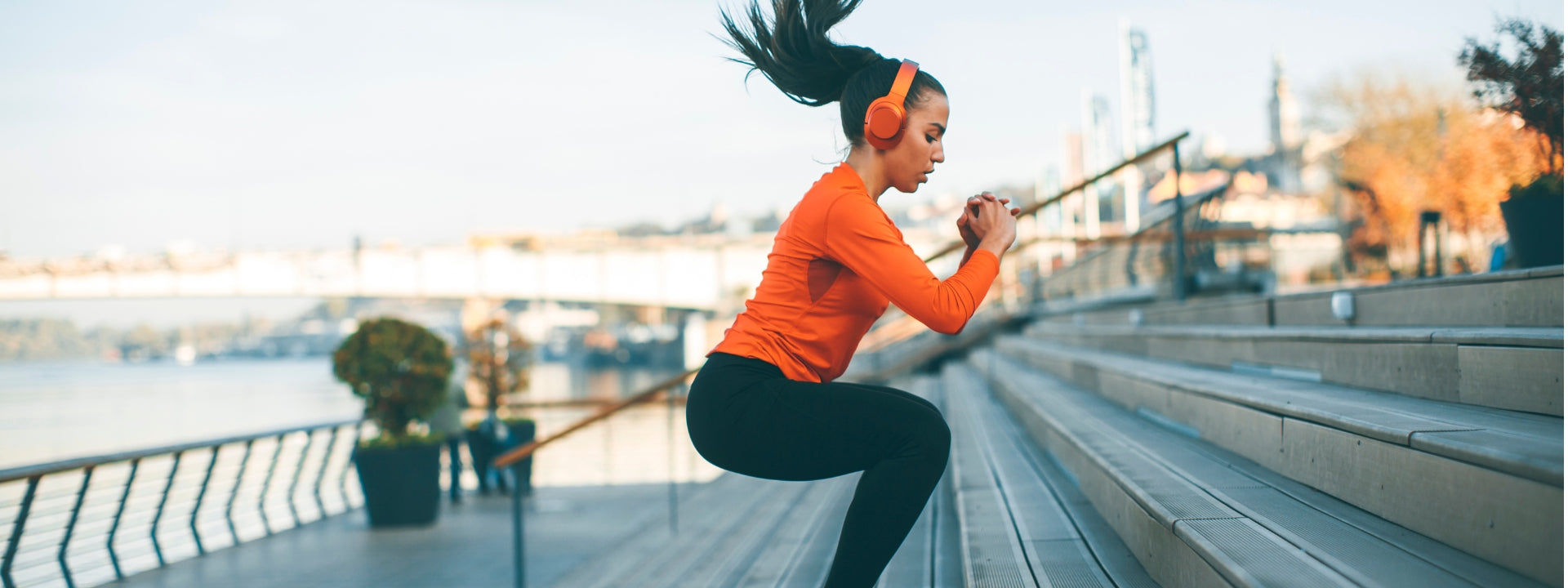 Athletic woman does jump squats outdoors