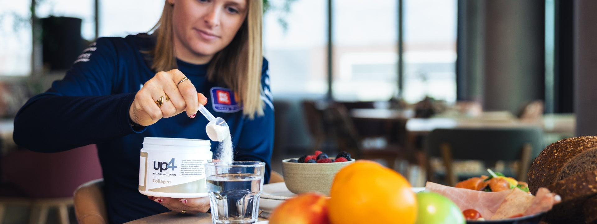 Female cyclist drinks a protein shake with Up4 on the bottle
