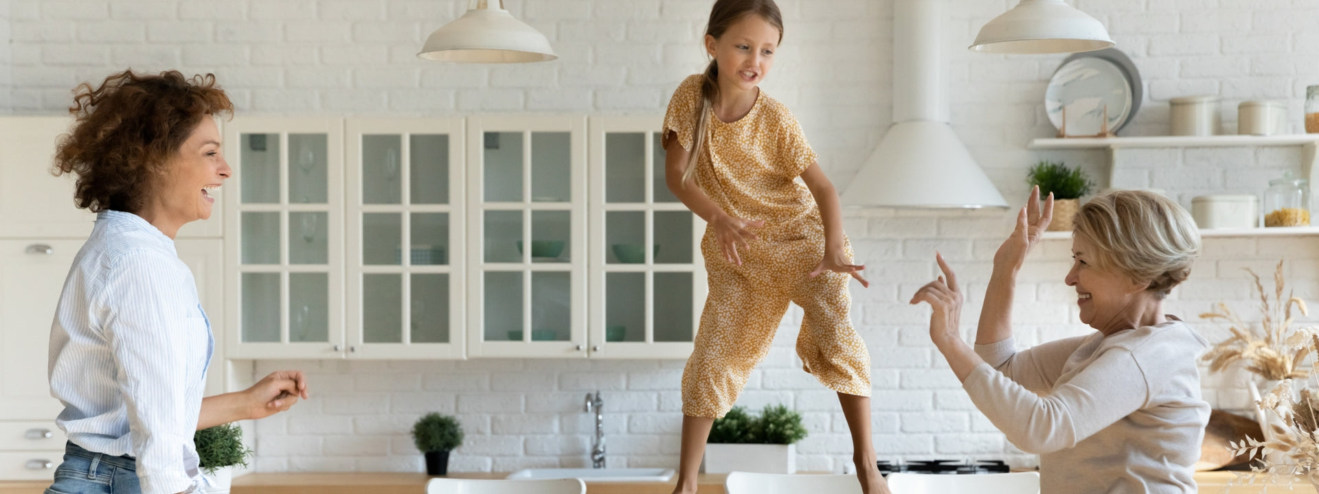 Three generations of women dance in the kitchen