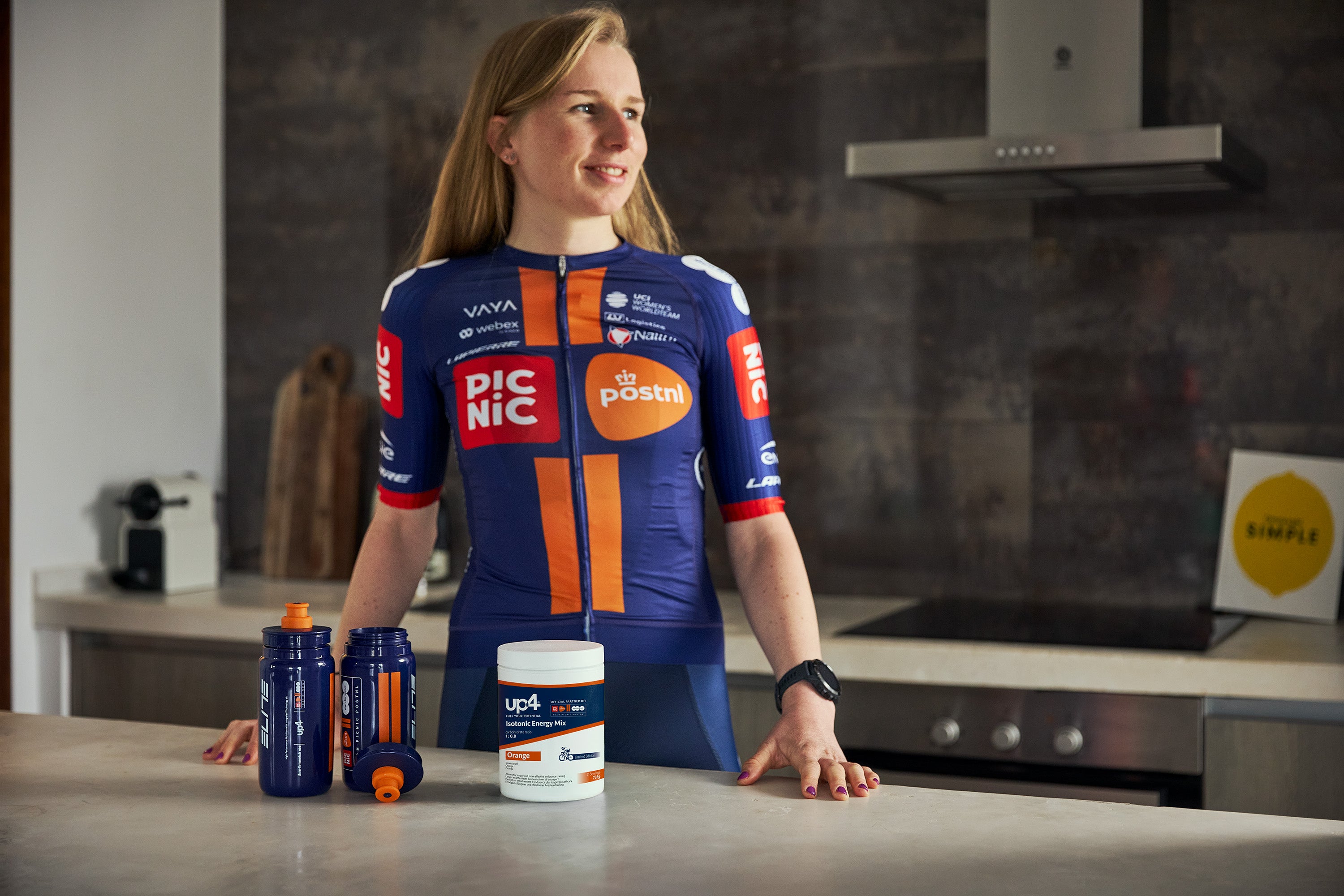 Person wearing a sports jersey with various brands in a kitchen setting